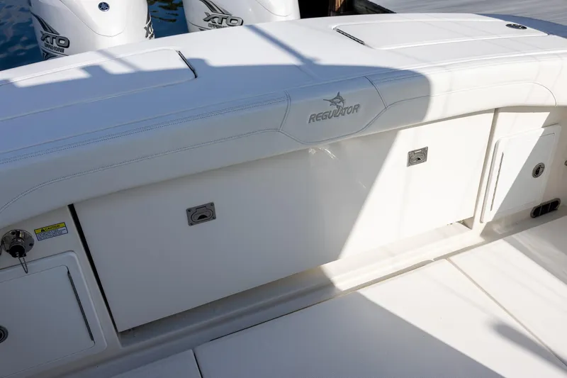 Slide: The Image of 2021 Regulator 31 boat with white seating and storage compartments. - 49