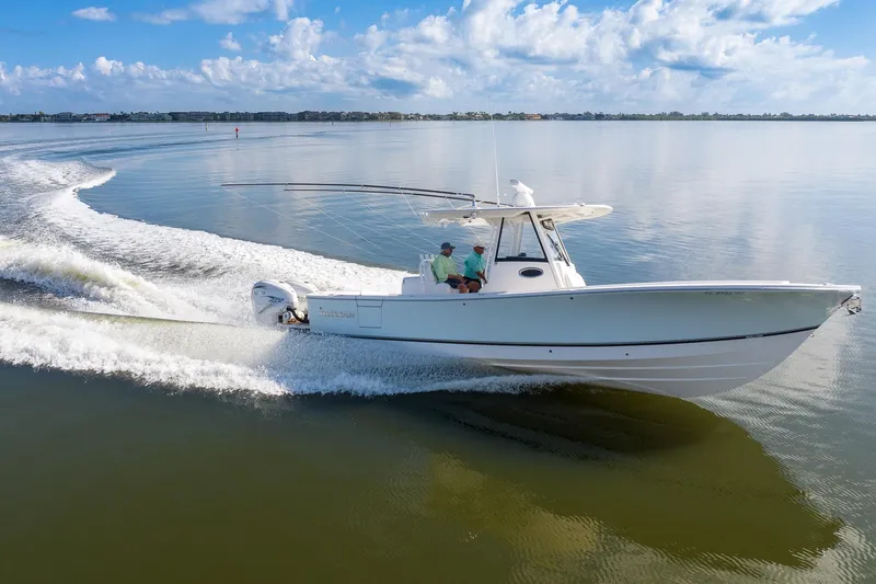 Slide: The Image of 2021 Regulator 31 boat cruising on calm water under a clear blue sky. - 5