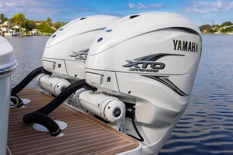 Slide: The Image of Twin Yamaha XTO Offshore engines on a 2021 Regulator 31 boat, docked on calm water. - 55