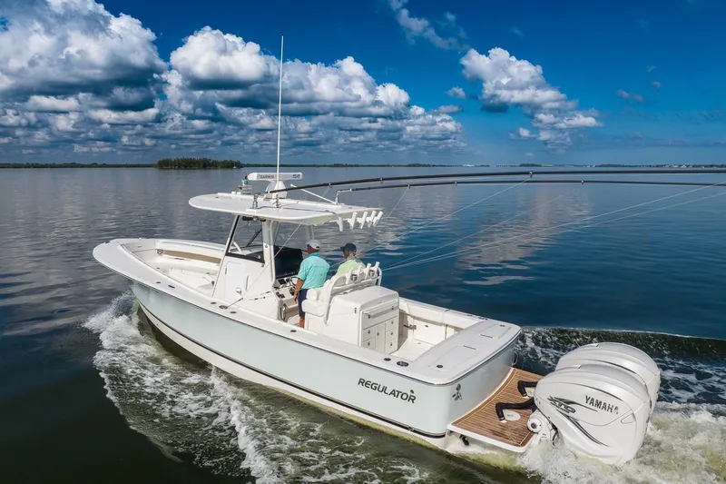 Slide: The Image of 2021 Regulator 31 boat cruising on calm water under a partly cloudy sky. - 7