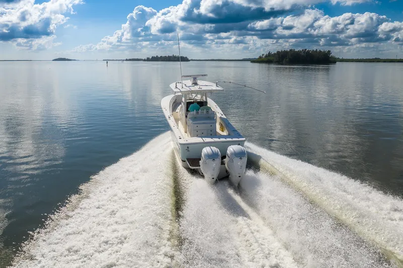 Slide: The Image of 2021 Regulator 31 boat cruising on calm water under a partly cloudy sky. - 9