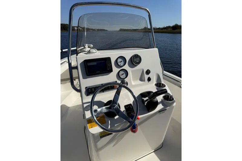 Slide: The Image of 2021 Key West 189 FS boat console with steering wheel and gauges on a calm waterway. - 13