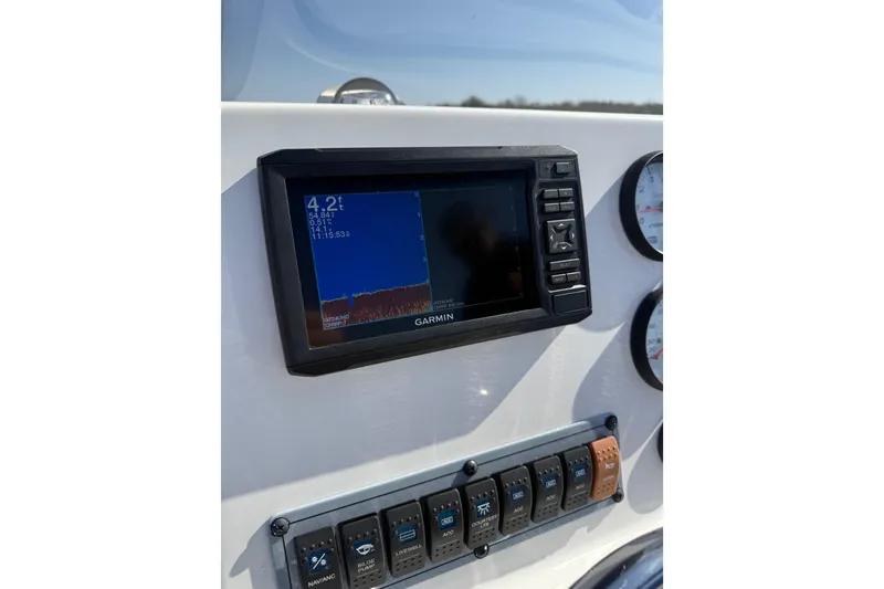 Slide: The Image of Garmin display on 2021 Key West 189 FS boat dashboard with control switches. - 20