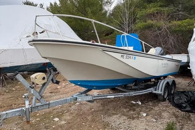 The Image of 1984 Boston Whaler Outrage 22 boat on trailer, parked outdoors. - 0