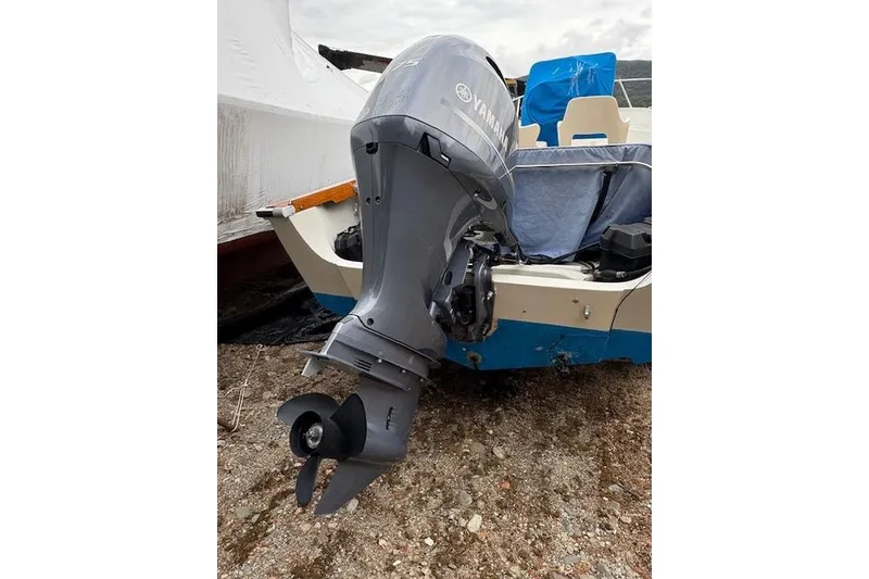 Slide: The Image of 1984 Boston Whaler Outrage 22 with Yamaha outboard motor on gravel surface. - 3