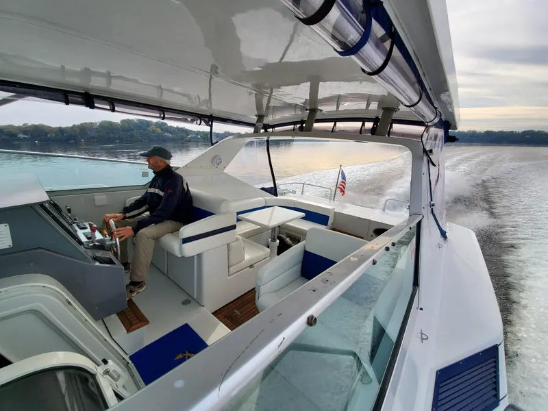 Slide: The Image of Man steering 1993 Giorgi 46 yacht on calm waters, American flag visible. - 1