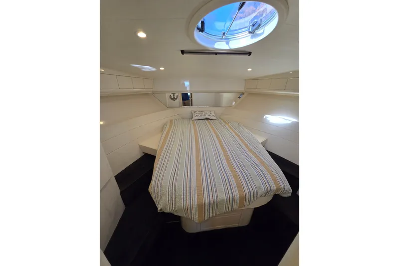Slide: The Image of 1993 Giorgi 46 yacht cabin with striped bedding and overhead hatch. - 118
