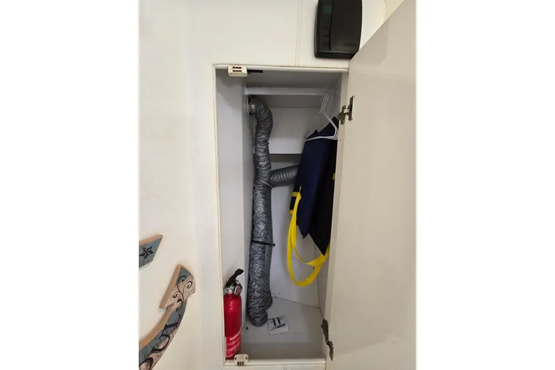 Slide: The Image of Cabinet interior with duct, fire extinguisher, and hanging items in Giorgi 46, 1993 model. - 120