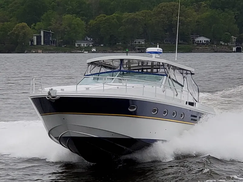 Slide: The Image of 1993 Giorgi 46 yacht cruising on a lake with lush green shoreline. - 2