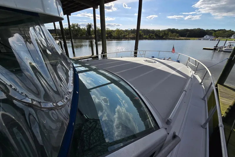 Slide: The Image of Giorgi 46 yacht from 1993 docked by a serene river under a clear sky. - 93