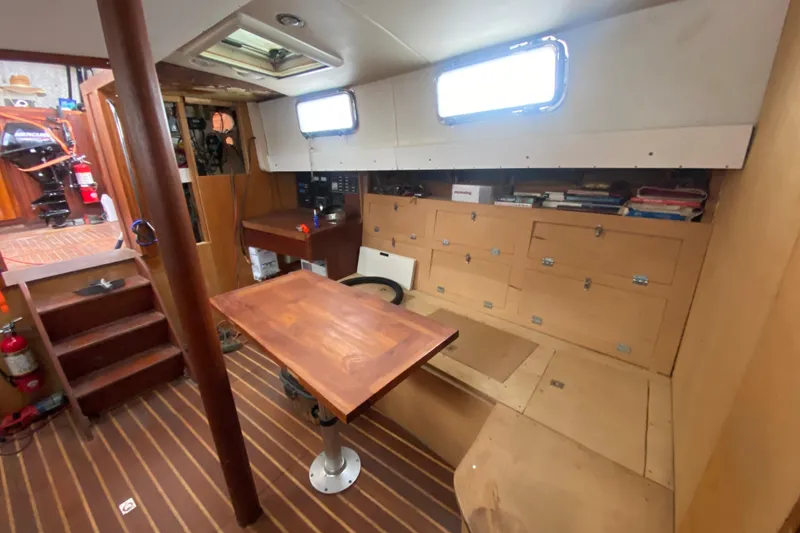 Slide: The Image of Interior of 1966 Vanguard Bermudian Sloop with wooden table, storage, and nautical equipment. - 10