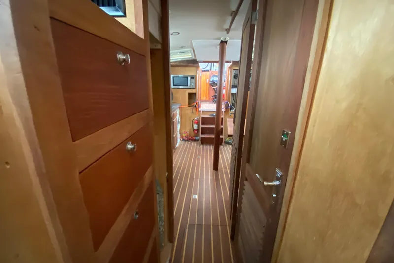 Slide: The Image of Interior of a 1966 Vanguard Bermudian Sloop with wooden cabinetry and striped flooring. - 17