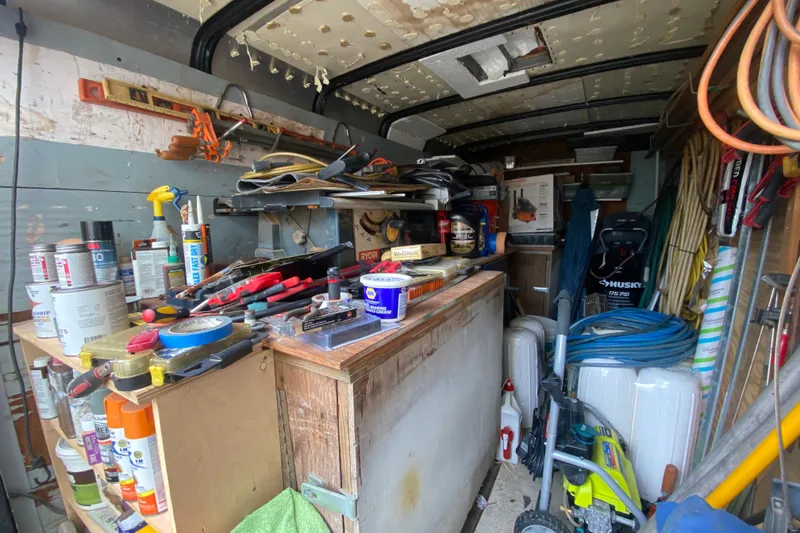 Slide: The Image of Cluttered workshop with tools, paint cans, and equipment inside a Vanguard Bermudian Sloop, 1966. - 30