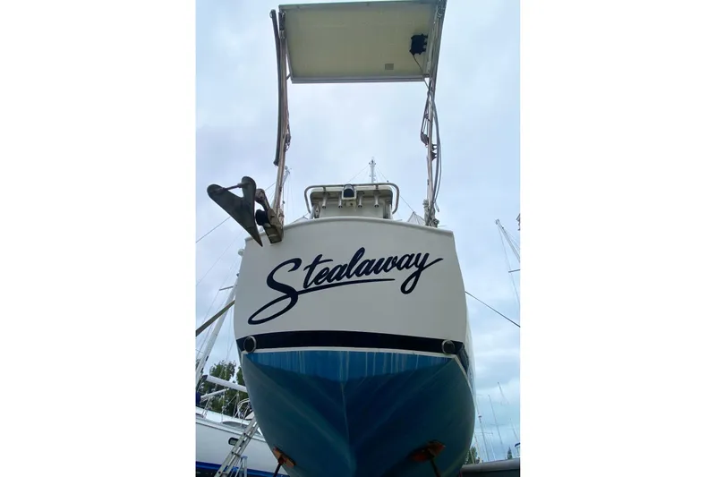 Slide: The Image of 1966 Vanguard Bermudian Sloop "Stealaway" with blue hull, docked and viewed from stern. - 6