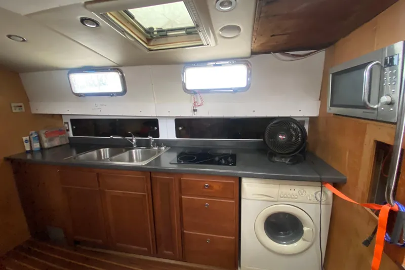 Slide: The Image of 1966 Vanguard Bermudian Sloop kitchen with sink, stove, washing machine, and microwave. - 9