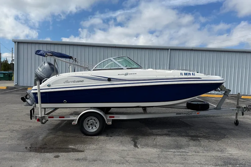 The Image of 2012 Hurricane SunDeck 187 OB boat on trailer, parked outdoors. - 1