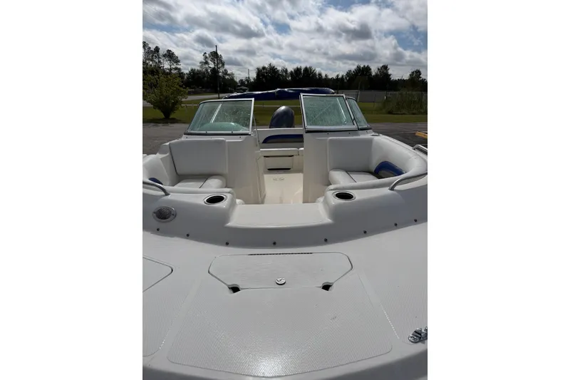 Slide: The Image of 2012 Hurricane SunDeck 187 OB boat interior with seating and windshield under cloudy sky. - 11