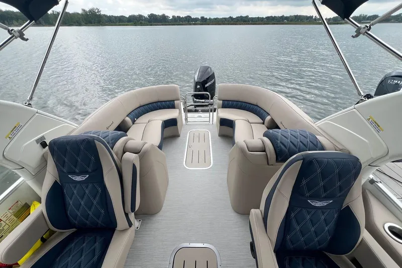 Slide: The Image of Luxurious 2026 Bennington 25 RTFBA pontoon boat interior with plush seating on a serene lake. - 4