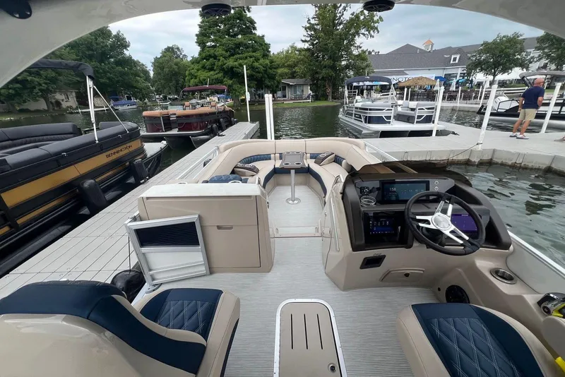 Slide: The Image of 2026 Bennington 25 RTFBA pontoon boat interior at dock, featuring modern controls and seating. - 5