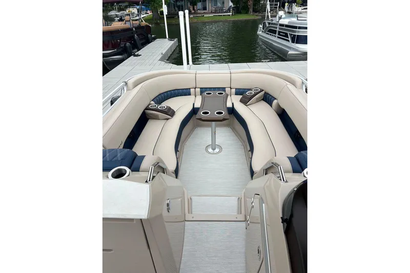 Slide: The Image of 2026 Bennington 25 RTFBA pontoon boat with luxurious seating and cup holders at a dock. - 6