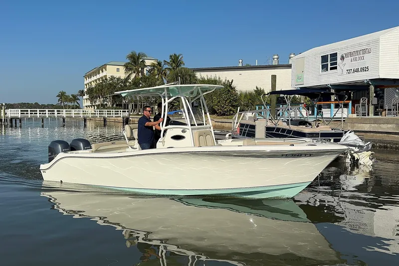Slide: The Image of 2015 NauticStar 2500XS Offshore boat on calm water near dock. - 0