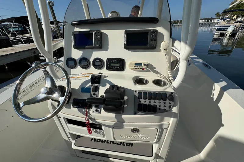 Slide: The Image of 2015 NauticStar 2500XS Offshore boat console with steering wheel and navigation equipment. - 12
