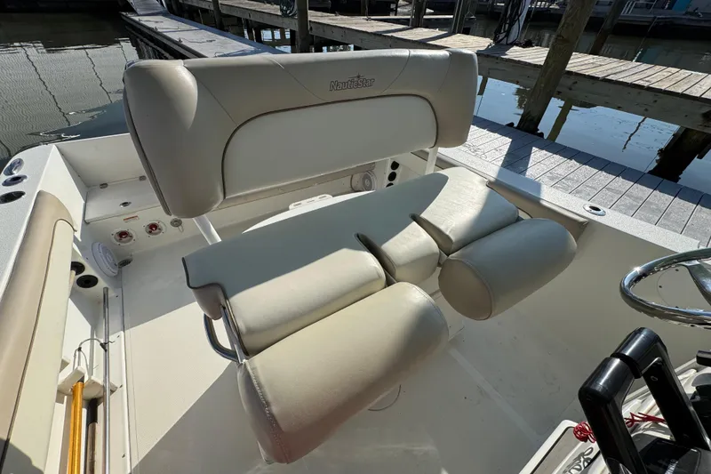 Slide: The Image of 2015 NauticStar 2500XS Offshore boat interior with cushioned seating and steering wheel. - 14