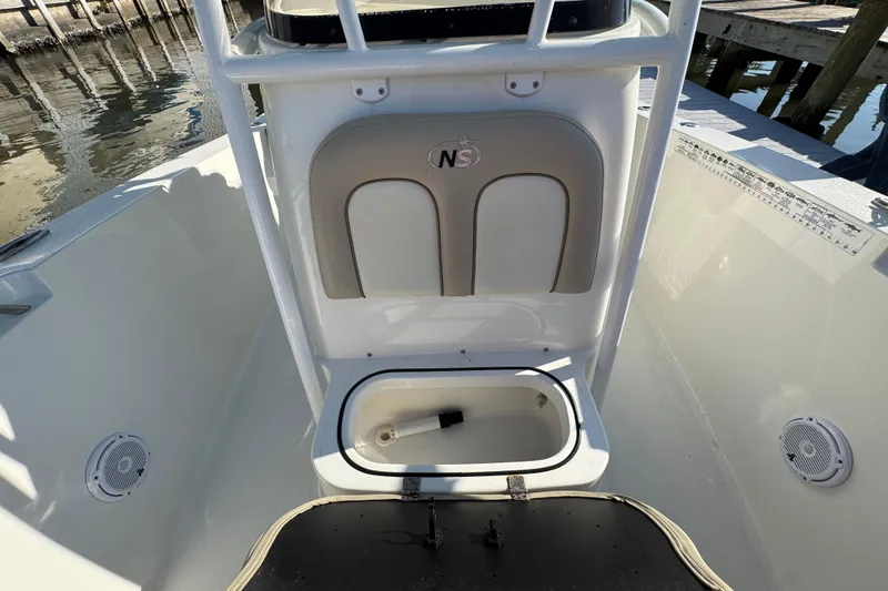 Slide: The Image of 2015 NauticStar 2500XS Offshore boat interior with storage compartment and speakers. - 6