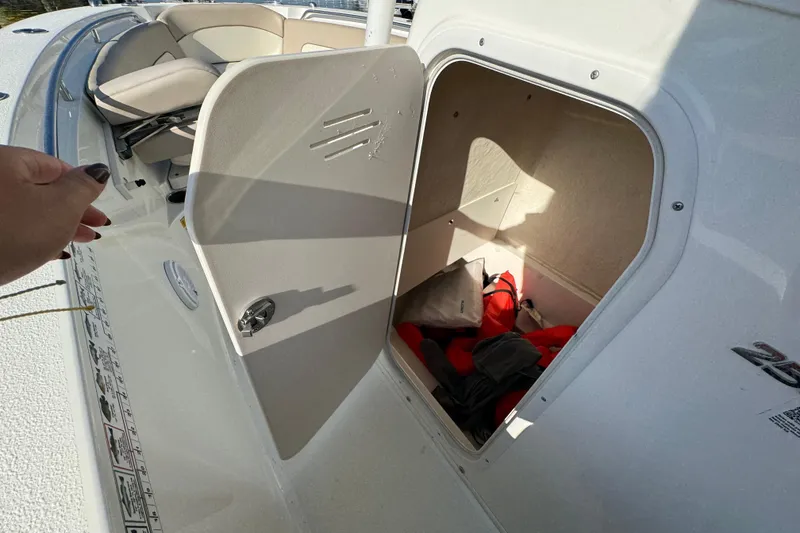 Slide: The Image of 2015 NauticStar 2500XS Offshore boat storage compartment with life jackets and gear. - 7