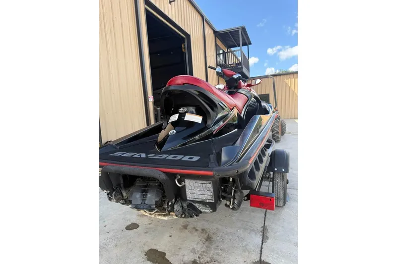 Slide: The Image of 2008 Seadoo RXT jet ski on trailer, parked outside a building under a clear sky. - 3