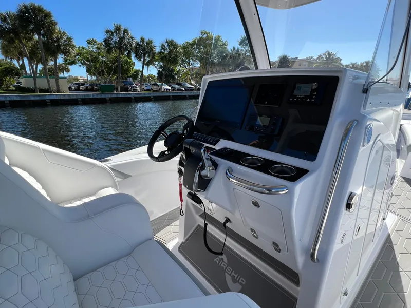 Slide: The Image of 2024 Airship 340 boat cockpit with modern controls and waterfront view. - 11