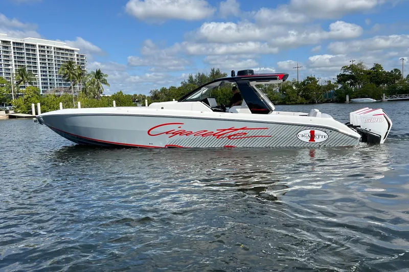 Slide: The Image of 2025 Cigarette 41 Nighthawk boat on water, sleek design, modern architecture, sunny day. - 12