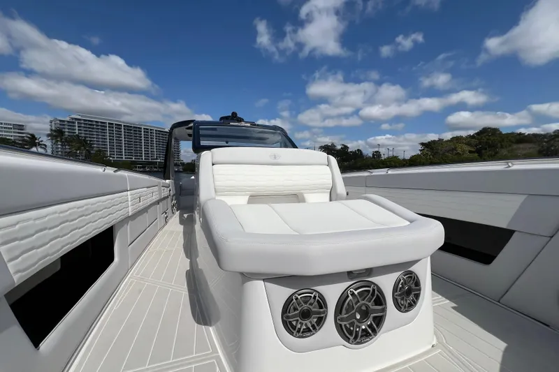 Slide: The Image of 2025 Cigarette 41 Nighthawk boat with luxurious seating and speakers under a clear blue sky. - 32