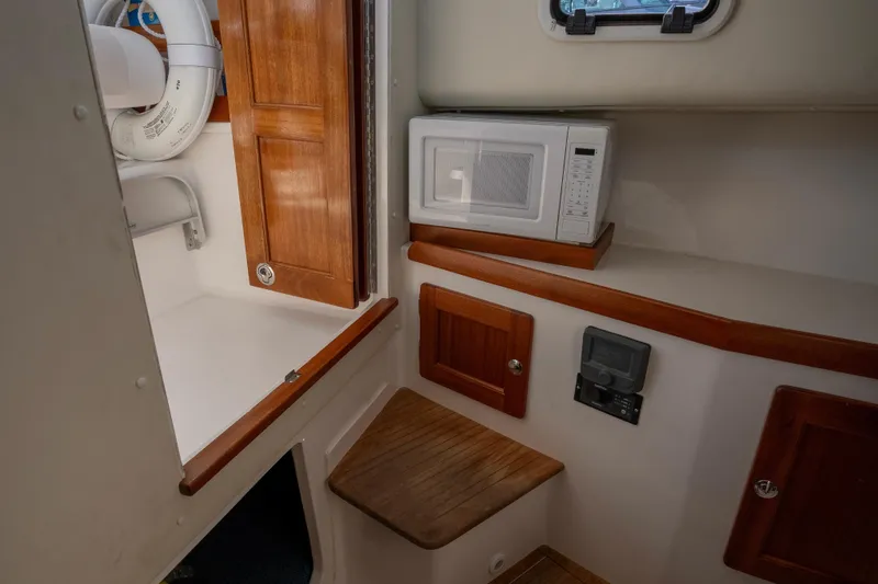 Slide: The Image of 2021 NorthCoast 315 HT cabin interior with microwave and wooden cabinetry. - 11