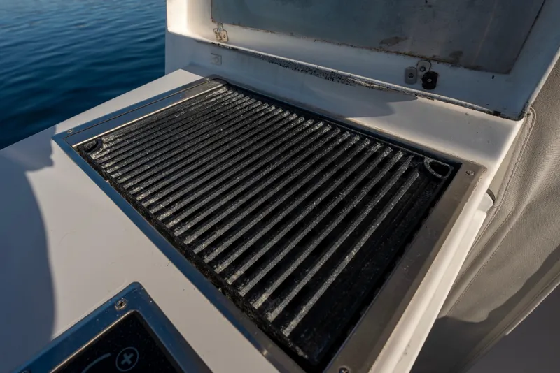 Slide: The Image of Grill on 2021 NorthCoast 315 HT boat, open lid, near water. - 14