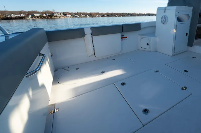 Slide: The Image of 2021 NorthCoast 315 HT boat deck with seating, storage, and scenic waterfront view. - 16