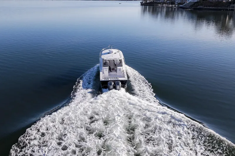 Slide: The Image of 2021 NorthCoast 315 HT boat cruising on calm water, leaving a wake. - 26