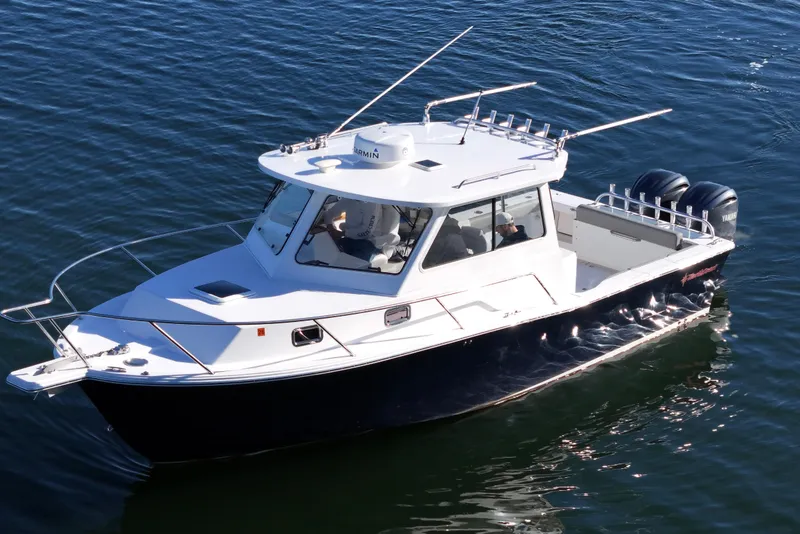 Slide: The Image of 2021 NorthCoast 315 HT boat cruising on water with dual outboard engines. - 31