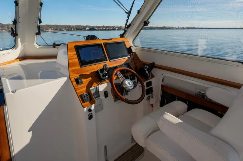 Slide: The Image of Interior view of 2021 NorthCoast 315 HT boat helm with dual screens and wooden accents. - 4