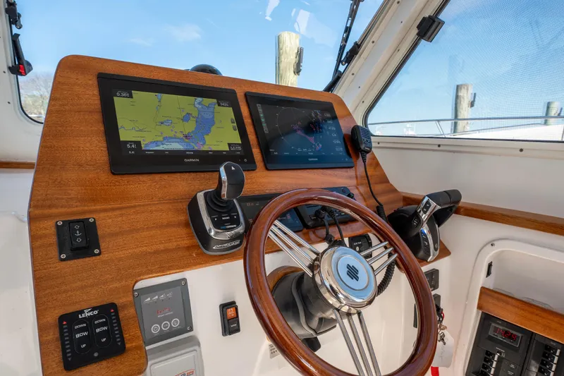 Slide: The Image of 2021 NorthCoast 315 HT helm with dual Garmin displays and wooden steering wheel. - 5
