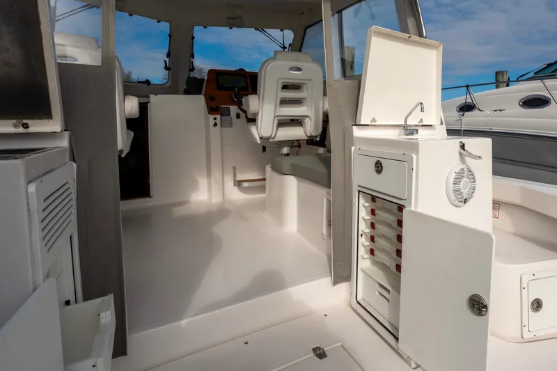 Slide: The Image of 2021 NorthCoast 315 HT boat interior with helm, storage, and seating. - 7