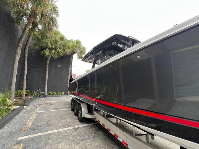 Slide: The Image of 2025 Nor-Tech 400 Supersport boat on trailer, parked near palm trees. - 6