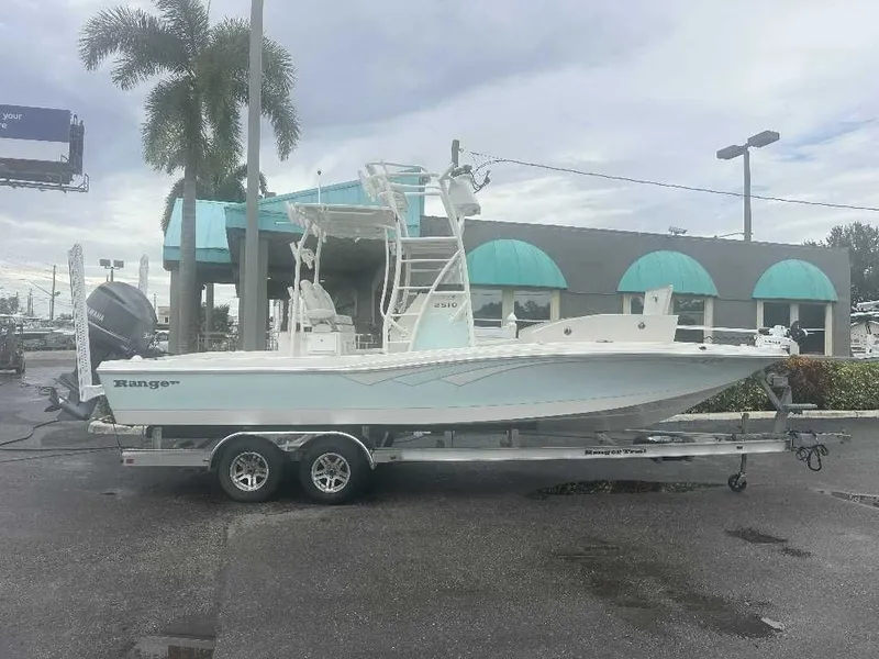The Image of 2019 Ranger 2510 Bay Ranger boat on trailer, parked outdoors near palm trees. - 0