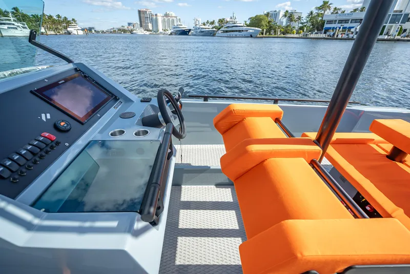 Slide: The Image of 2024 Goldfish 28 Tender boat interior with orange seats and modern dashboard. - 11