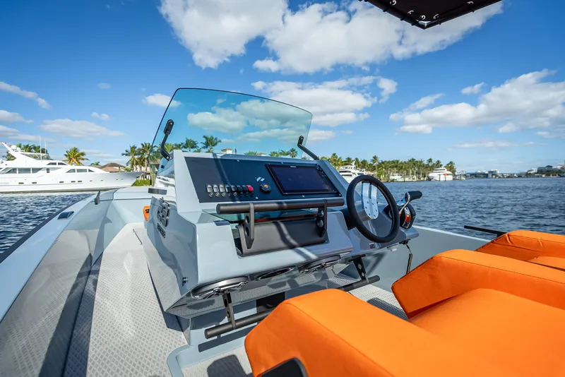 Slide: The Image of Goldfish 28 Tender 2024 model boat dashboard with orange seats on a sunny day. - 17