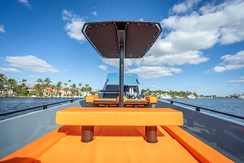 Slide: The Image of 2024 Goldfish 28 Tender boat with orange seating and canopy on a sunny day. - 5