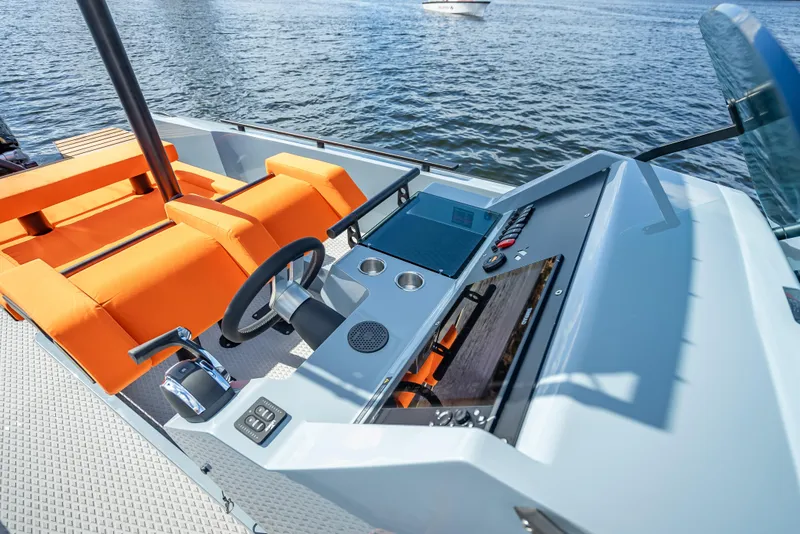 Slide: The Image of Goldfish 28 Tender 2024 model with orange seating and modern dashboard on the water. - 7