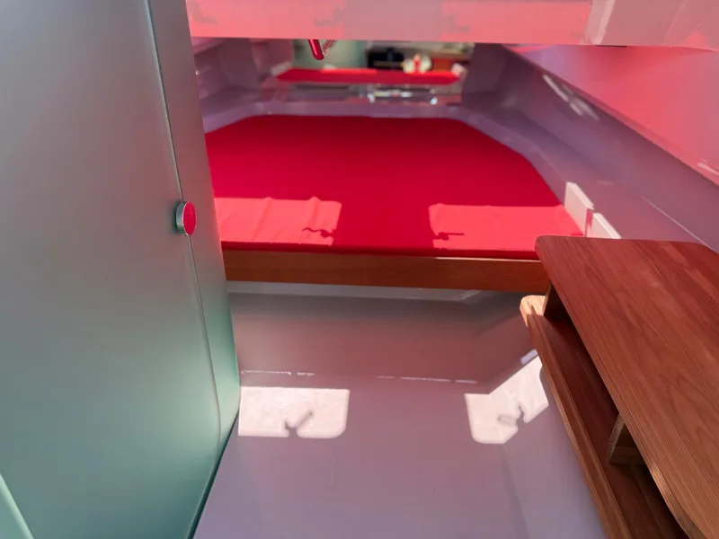 Slide: The Image of Interior of 2024 Goldfish 46 Open boat with red bedding and wooden accents. - 16