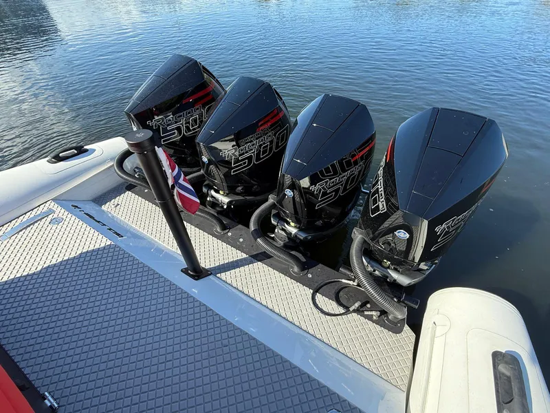Slide: The Image of Four powerful outboard motors on a 2024 Goldfish 46 Open boat, docked on calm water. - 9