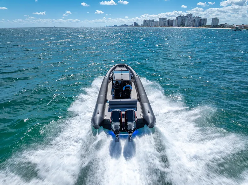 Slide: The Image of Goldfish X10 Scout 2024 boat speeding on ocean near city skyline. - 5